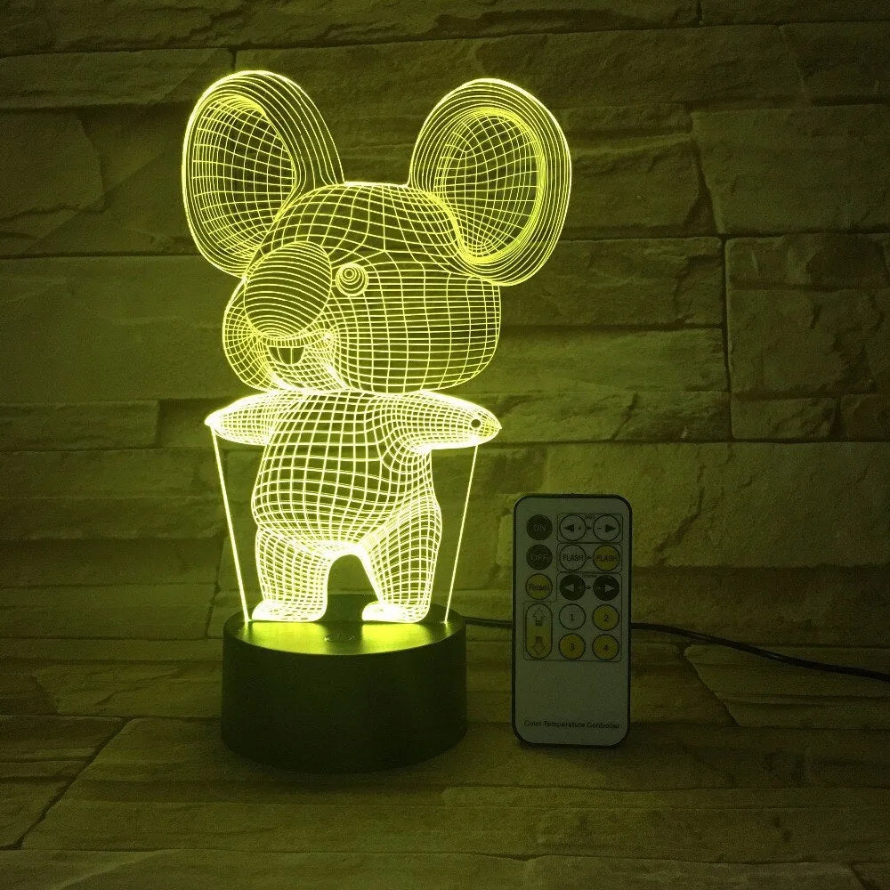 Black Koala night light with LED illumination on a bedside table.