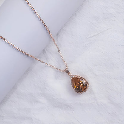 Rose gold geometric water drop pendant necklace on a model, showing adjustable chain and sparkling stone inlay.