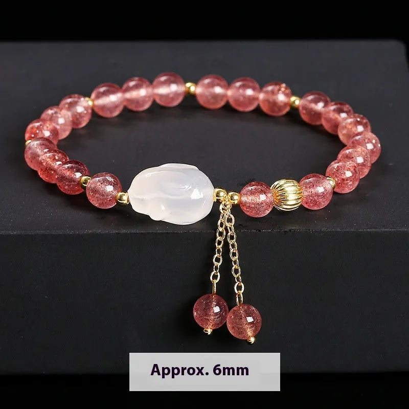 Women's strawberry quartz agate bracelet with 6mm round beads and white rabbit charm.