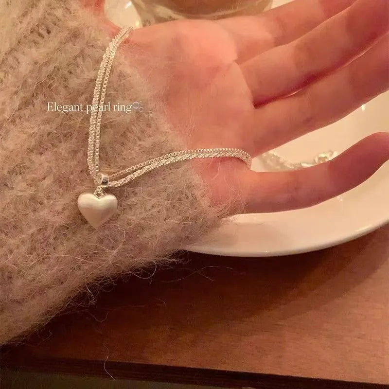 Double-layer brushed heart pendant necklace on adjustable silver-toned chain