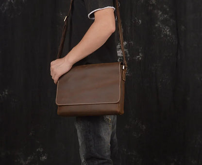 Vintage brown leather men's messenger bag with a cover flap, showing the internal document and phone pockets.