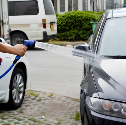 Blue telescopic water hose with high-pressure gun, expanded for use in garden watering