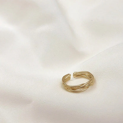 Adjustable twist metal ring in a gold tone, featuring a modern geometric design with a vintage-inspired flair.