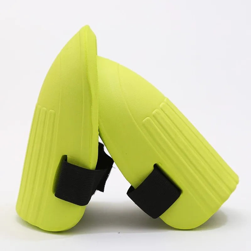 A pair of rectangular EVA foam knee pads in army green colour, placed on a garden soil background.