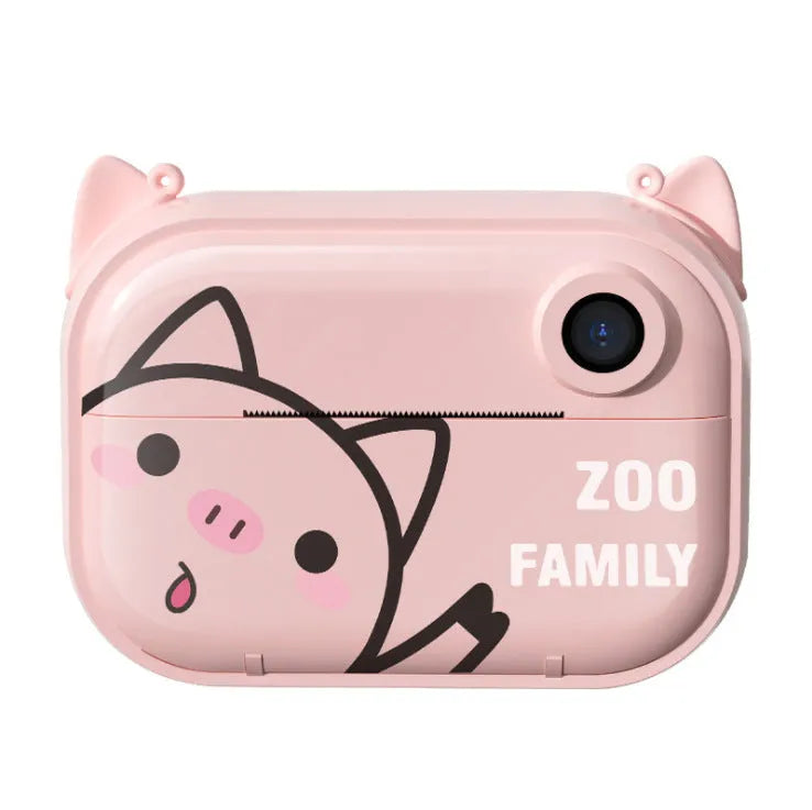 Pink instant print digital camera with LCD screen on a table next to printed photos and accessories.