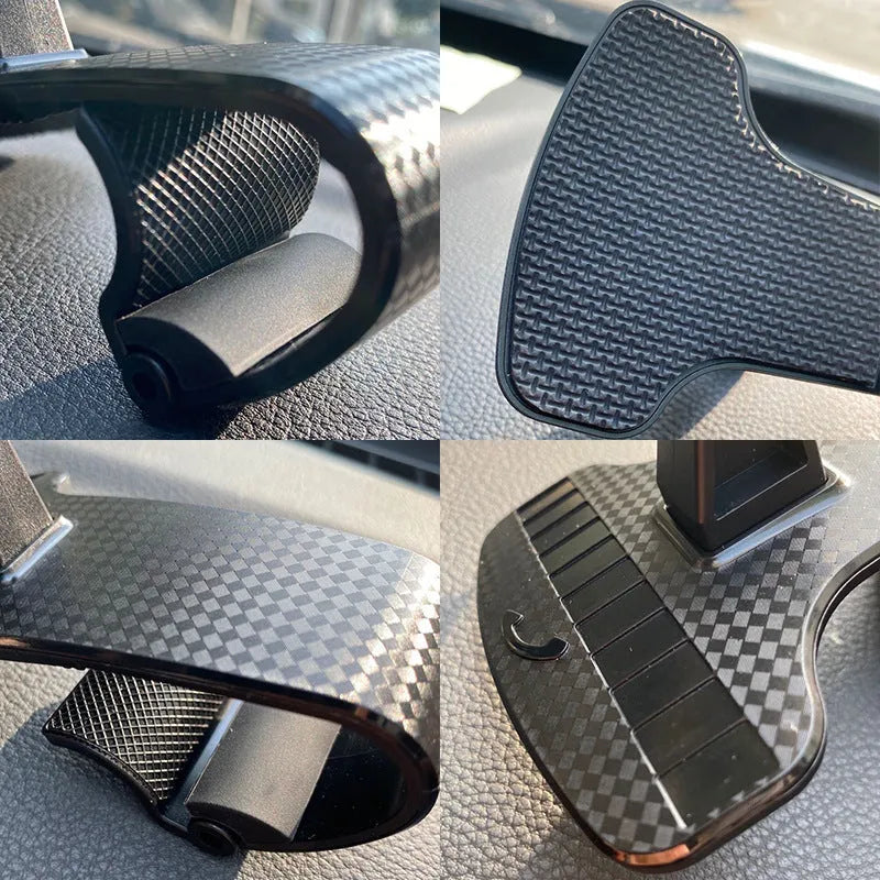 Black universal car phone holder with 360-degree rotating head on a car dashboard.