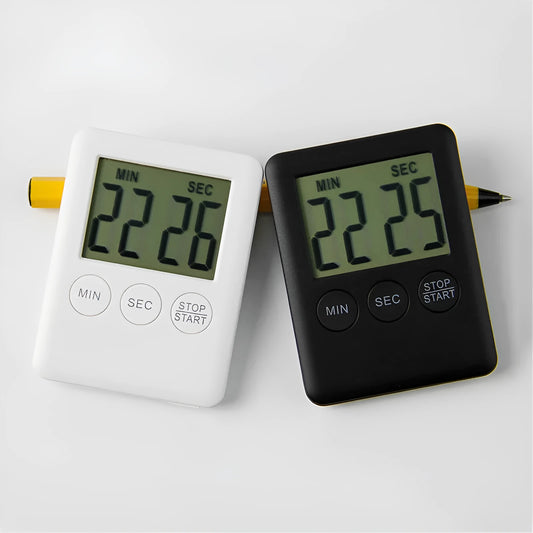 Black and white metal kitchen timer with magnetic back on a refrigerator door