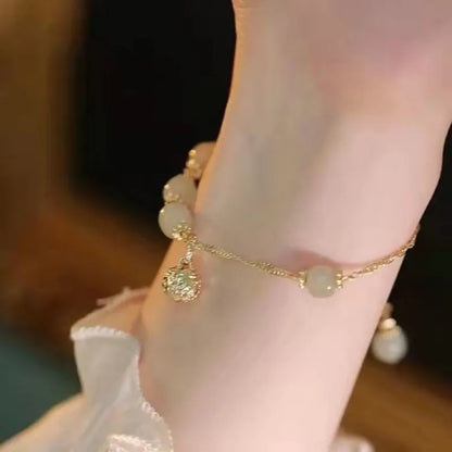 Chinese style glass bead bracelet with bamboo joint design on wrist.