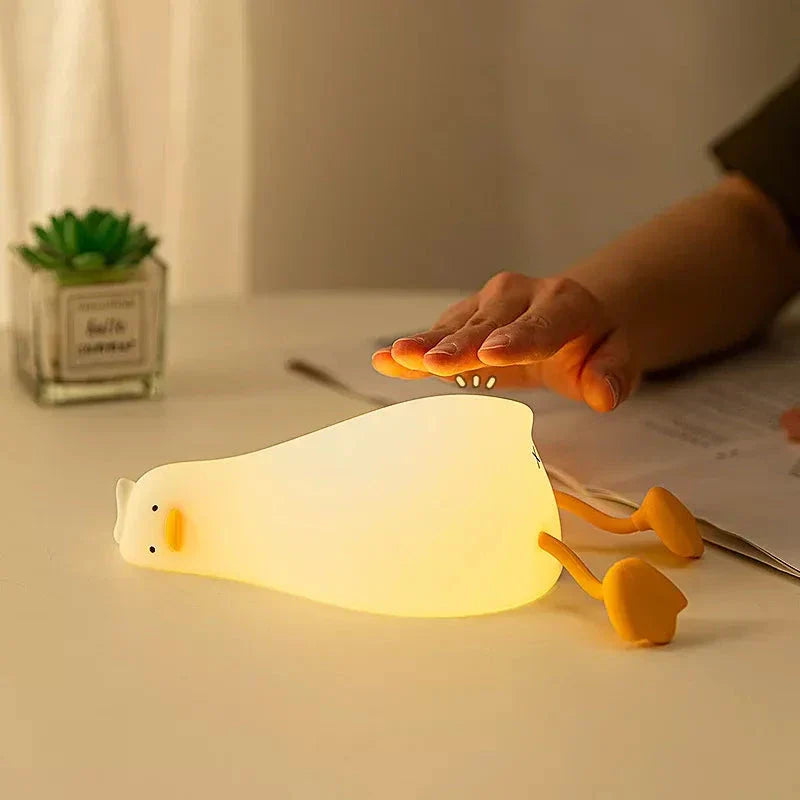 A white, duck-shaped LED night light with a soft, warm glow, providing a cozy and charming addition to any room