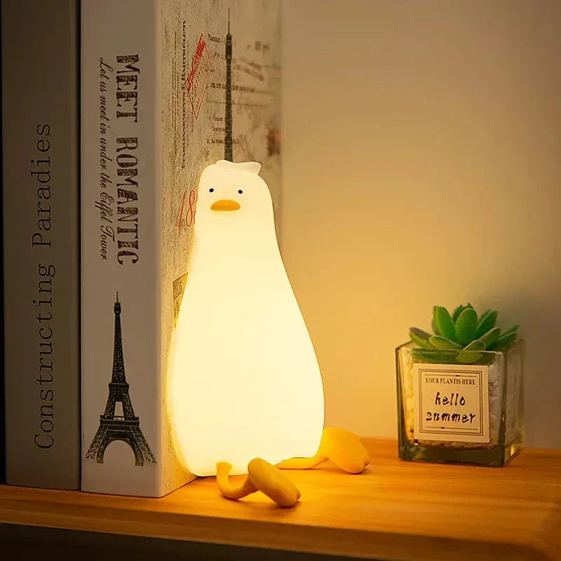 A white, duck-shaped LED night light with a soft, warm glow, providing a cozy and charming addition to any room