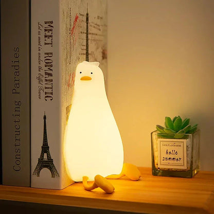 A white, duck-shaped LED night light with a soft, warm glow, providing a cozy and charming addition to any room