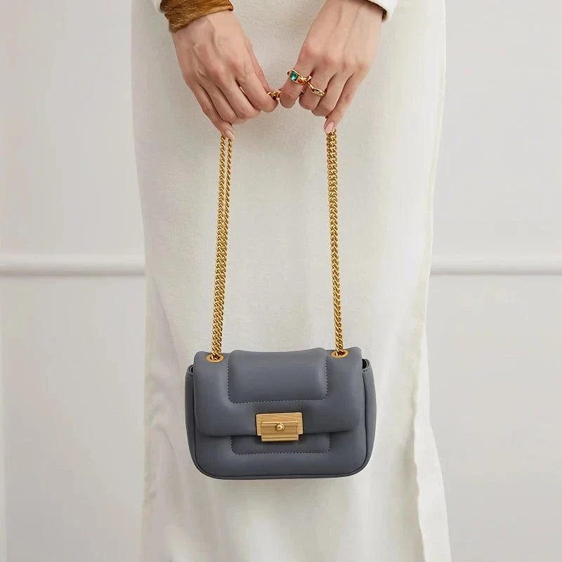 Premium grey split leather crossbody bag with adjustable metal chain strap, showcasing a compact and stylish design