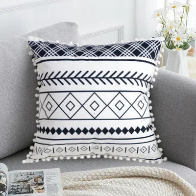 Bohemian style decorative pillowcase in light grey colour on a sofa.