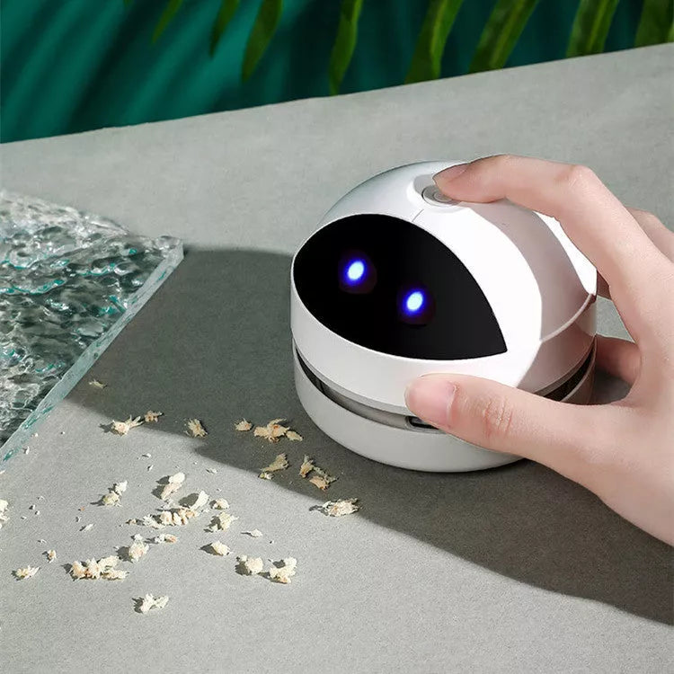 Compact USB charging wireless mini portable robot desktop vacuum cleaner on a desk