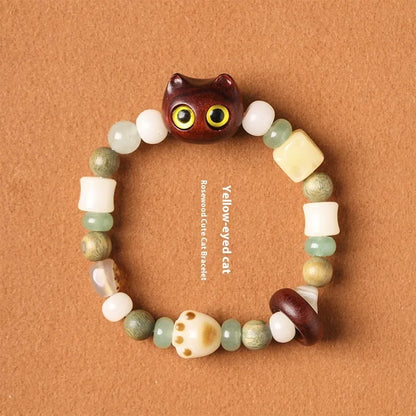 Hand-woven multi-treasure bracelet with jade, bodhi and ebony wood beads and a cartoon cat's paw charm.