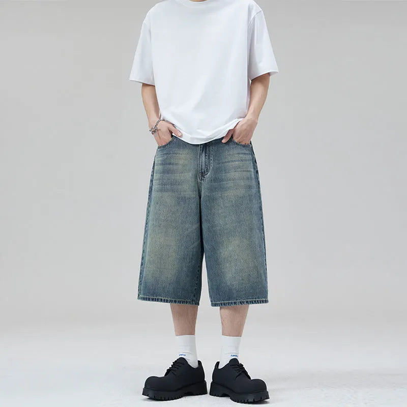 Men's loose straight denim shorts in light blue with cropped length ending above ankle, straight-leg cut