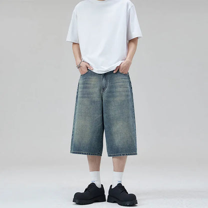 Men's loose straight denim shorts in light blue with cropped length ending above ankle, straight-leg cut