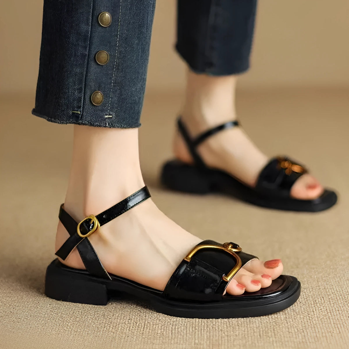 Women's black leather sandals with a thick rubber sole and button fastening on a round toe.