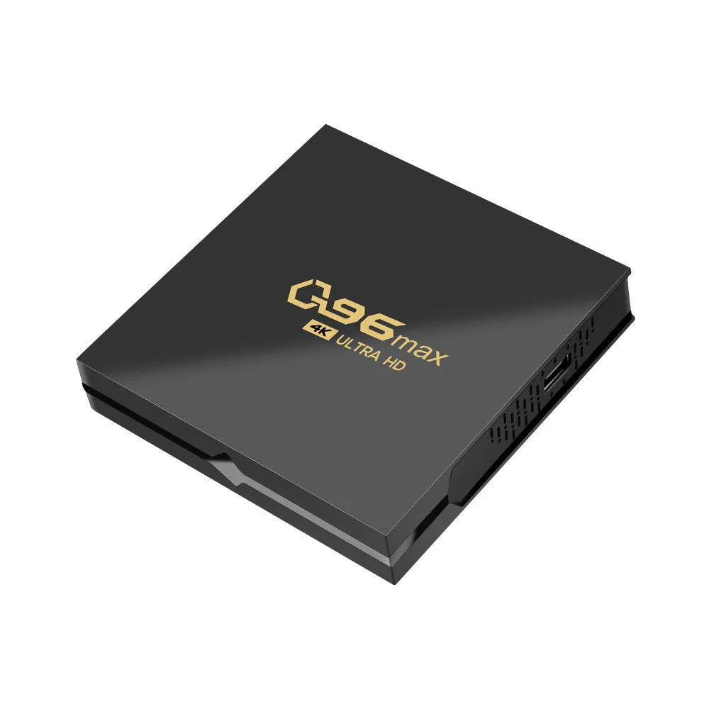 Q96 MAX Android TV set-top box with remote control and HDMI cable on a wooden surface.