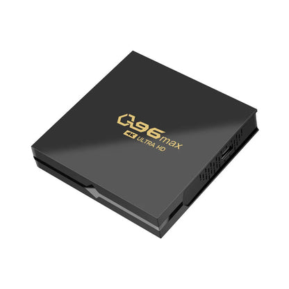 Q96 MAX Android TV set-top box with remote control and HDMI cable on a wooden surface.