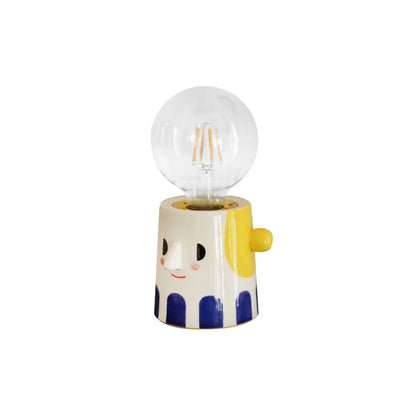 Handmade ceramic lamp with ball headlight design on a bedside table