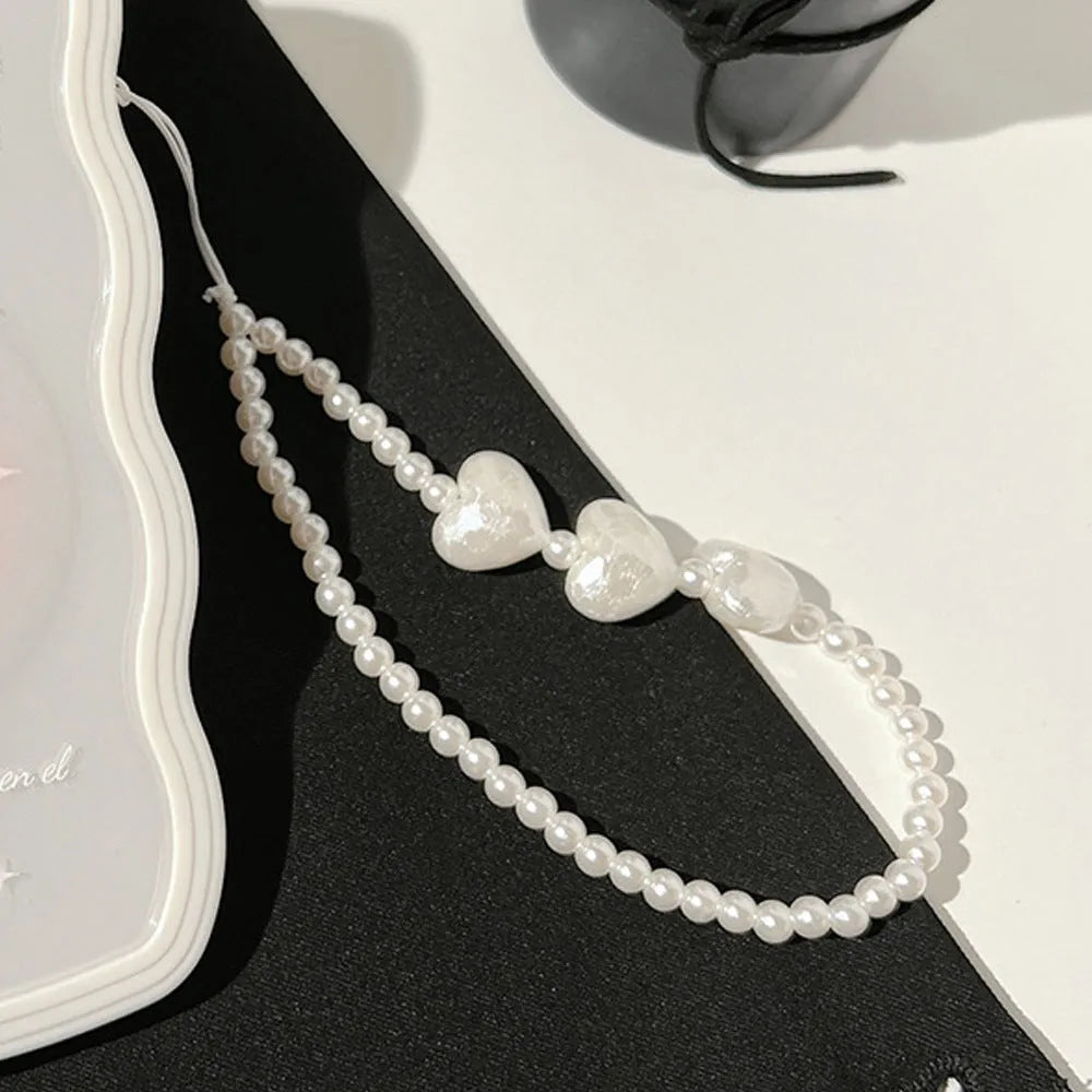 Transparent TPU iPhone case with 3D ice-through bow design on a mobile phone, showing optional white love lanyard attached.