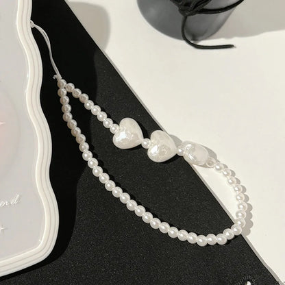 Transparent TPU iPhone case with 3D ice-through bow design on a mobile phone, showing optional white love lanyard attached.