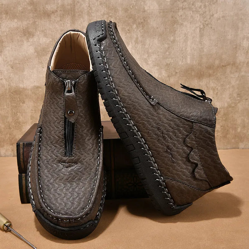 Men's slip-on loafers in black with round toe and sewing thread details, showing rubber sole