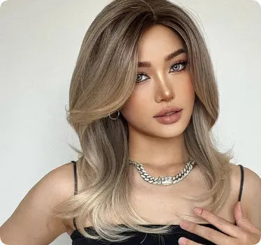 Mid-length curly synthetic wig with long bangs in a platinum gradient colour, shown on a wig stand.