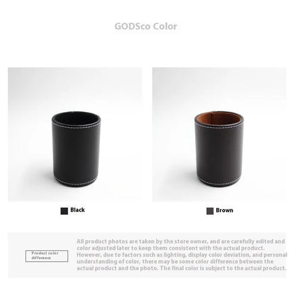 Round black leather pen container measuring 8.0cm diameter by 10.8cm height on wooden desk