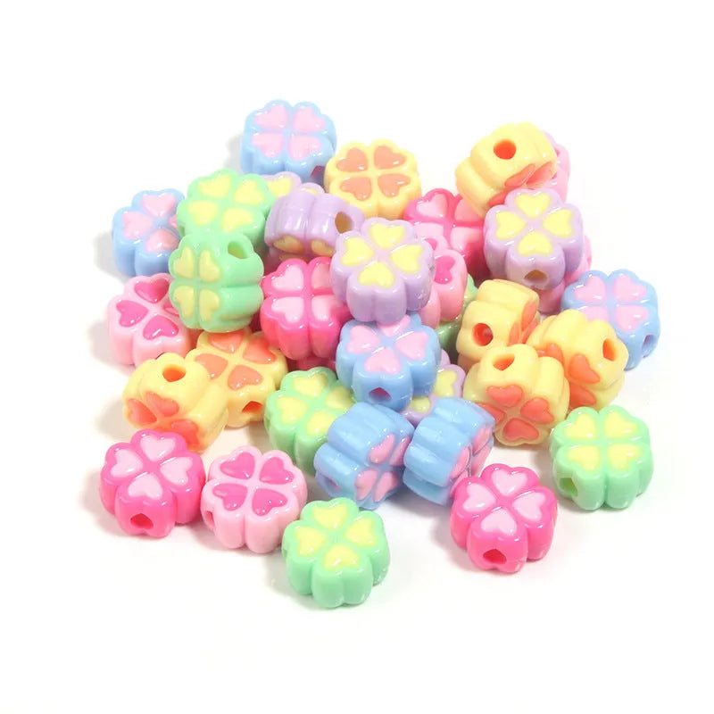 Assorted frosted acrylic four-leaf clover shaped beads in pink, green, and yellow, 15mm diameter.