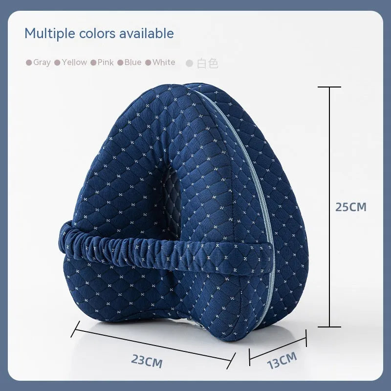 Dark blue jacquard heart-shaped memory foam leg pillow for adults on a bed.