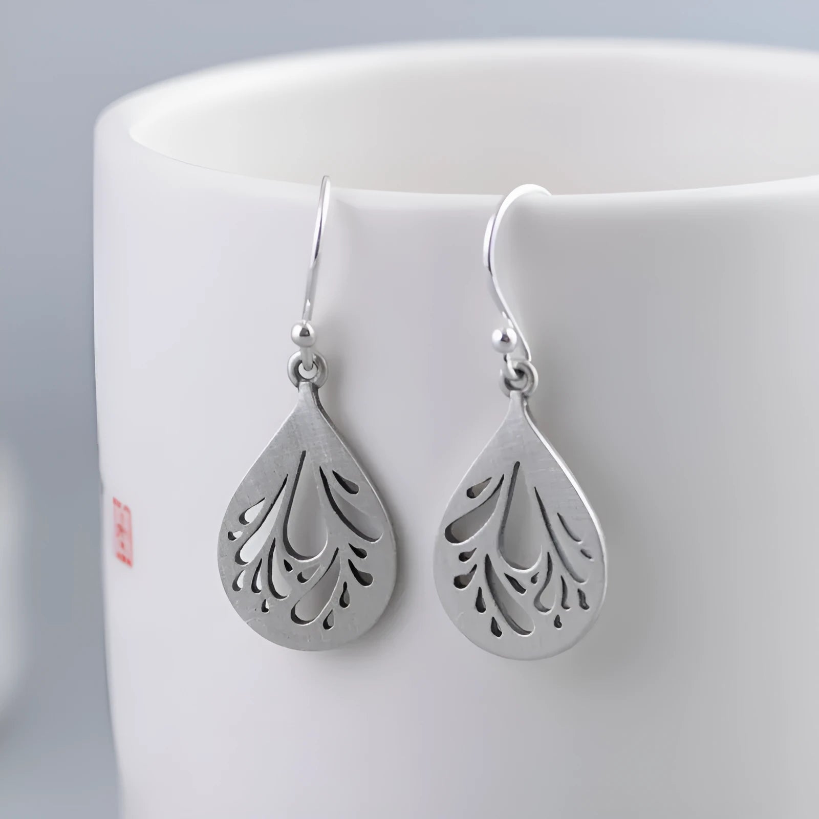 Retro hollow water drop shaped earrings in 925 silver with a textured grinding finish.