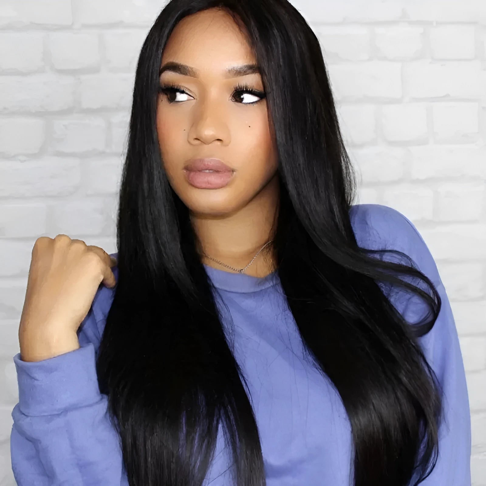 Long black straight synthetic wig on a stand, showing centre parting and full fringe