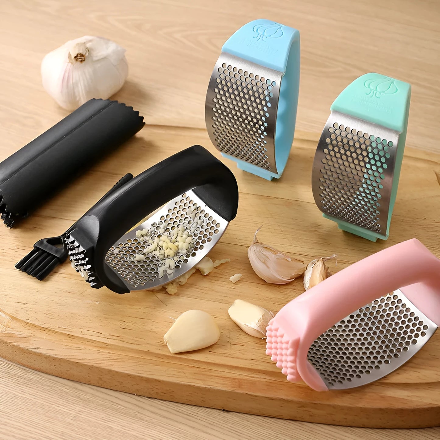 Stainless steel garlic press with coloured handles in a modern design, shown on a kitchen counter.