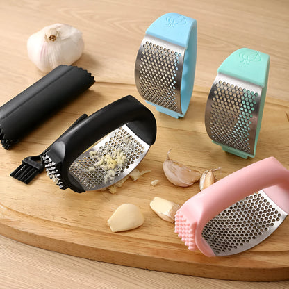 Stainless steel garlic press with coloured handles in a modern design, shown on a kitchen counter.