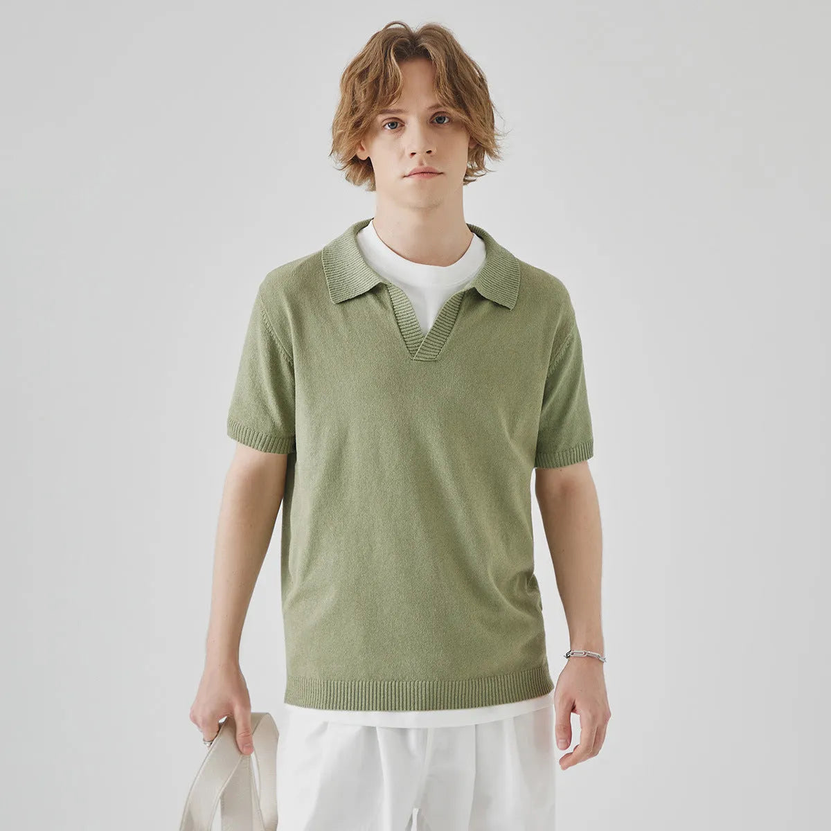 A man's solid-colour knitted polo t-shirt with short sleeves and a collar, shown in navy blue.