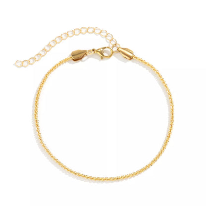Slim chain metallic anklet in gold and white with wave design