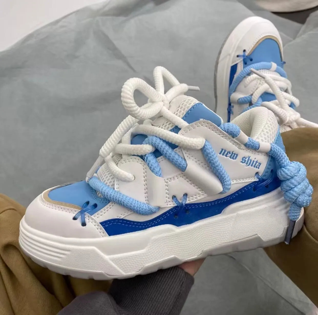 Women's grey chunky platform sneakers with white thick rubber sole and lace-up front.
