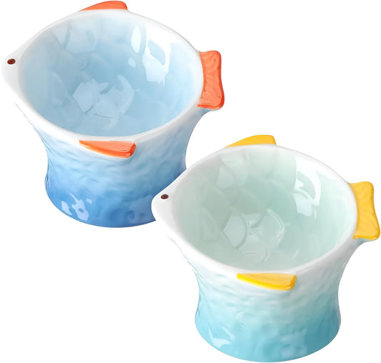 Set of four blue fish-shaped ceramic raised cat bowls on a wooden table