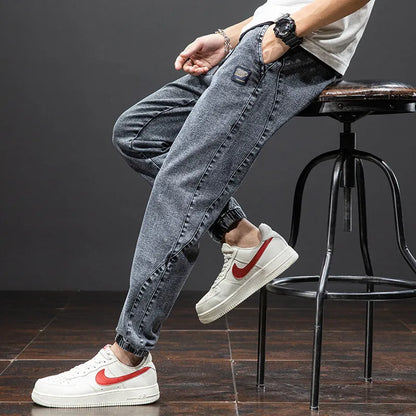 Men's blue cargo jeans with straight-leg fit, micro-elasticity fabric, and cargo pockets on a hanger.