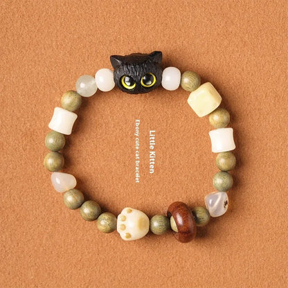 Hand-woven multi-treasure bracelet with jade, bodhi and ebony wood beads and a cartoon cat's paw charm.