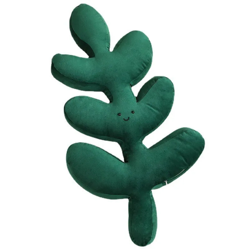 Green embroidered plant cushion with monstera leaf pattern on plush fabric
