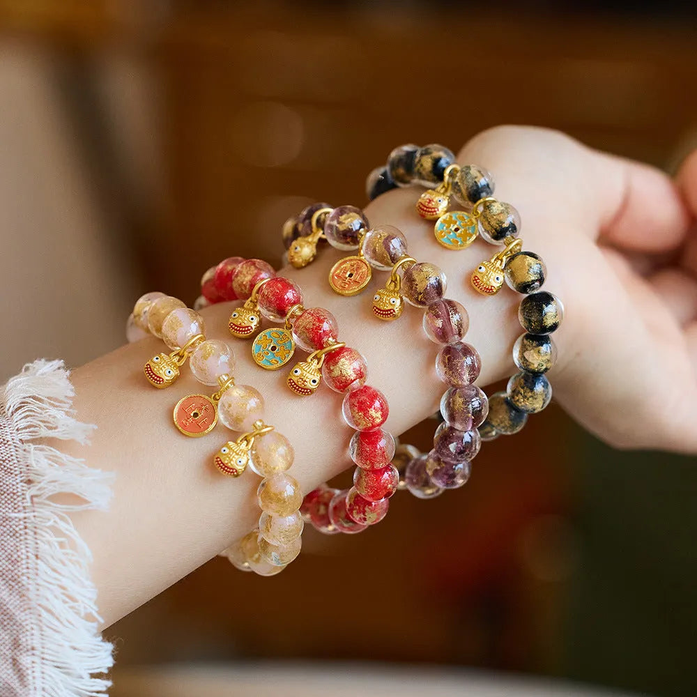 Handmade national style bracelet with coloured glaze swallowing gold beast charm on beaded band.