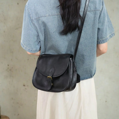 Genuine leather messenger bag in brown colour showing flap closure and textured cowhide material