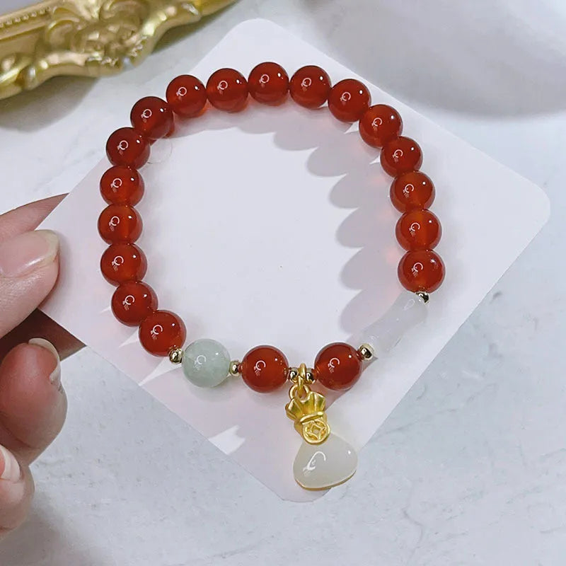 Close-up of a red agate bracelet featuring a detailed dragon design in a Chinese style.
