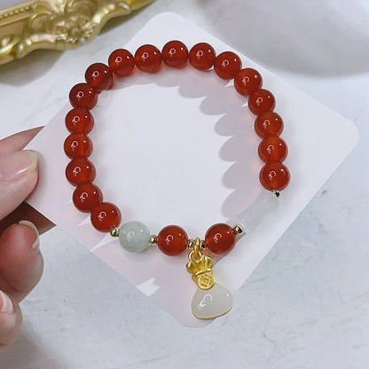 Close-up of a red agate bracelet featuring a detailed dragon design in a Chinese style.