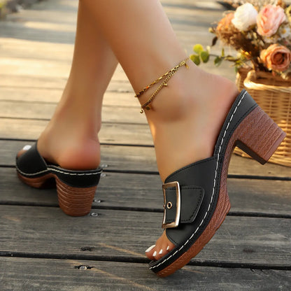 Women's black chunky heel slippers with a metal buckle on the strap and a rubber sole.