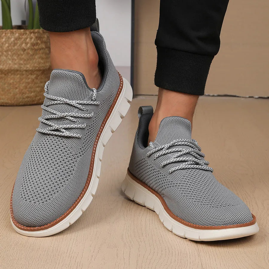 Men's grey and black low-top casual sneakers with a breathable mesh fabric upper.