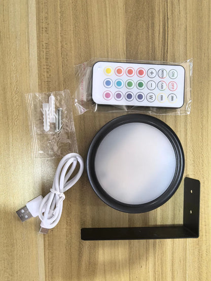 Black magnetic LED painting lamp with remote control on a white wall.